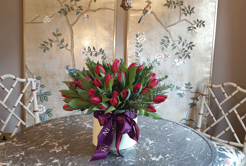 Red tulip flowers presented in luxury hatbox